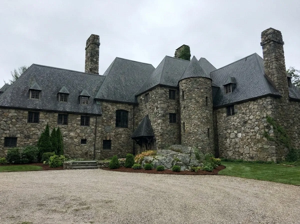 Hilltop Castle front facade — stone construction with turrets, dormers, and slate roof